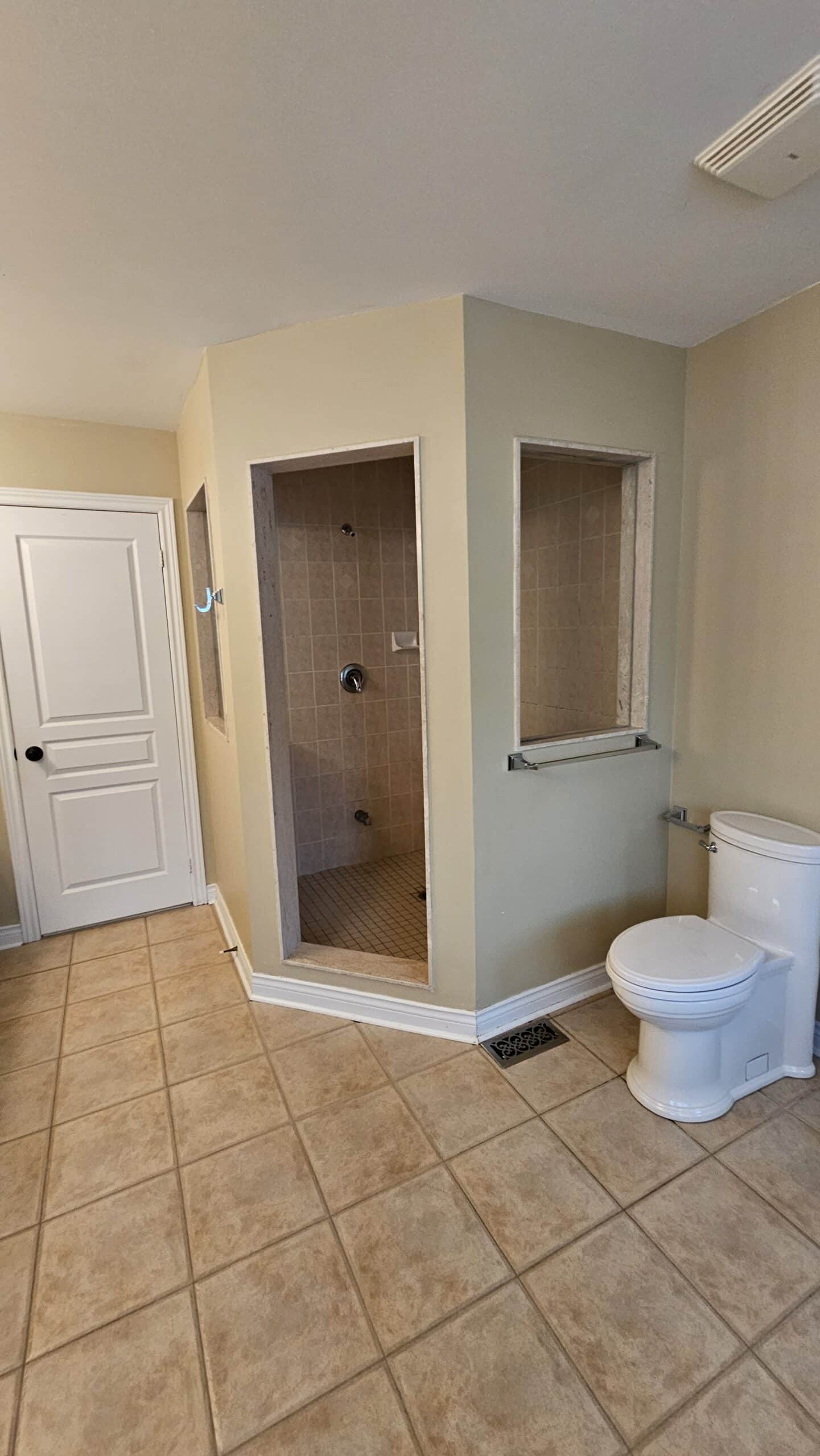 Dark and dingy shower with no glass and awkward windows. Horrible design