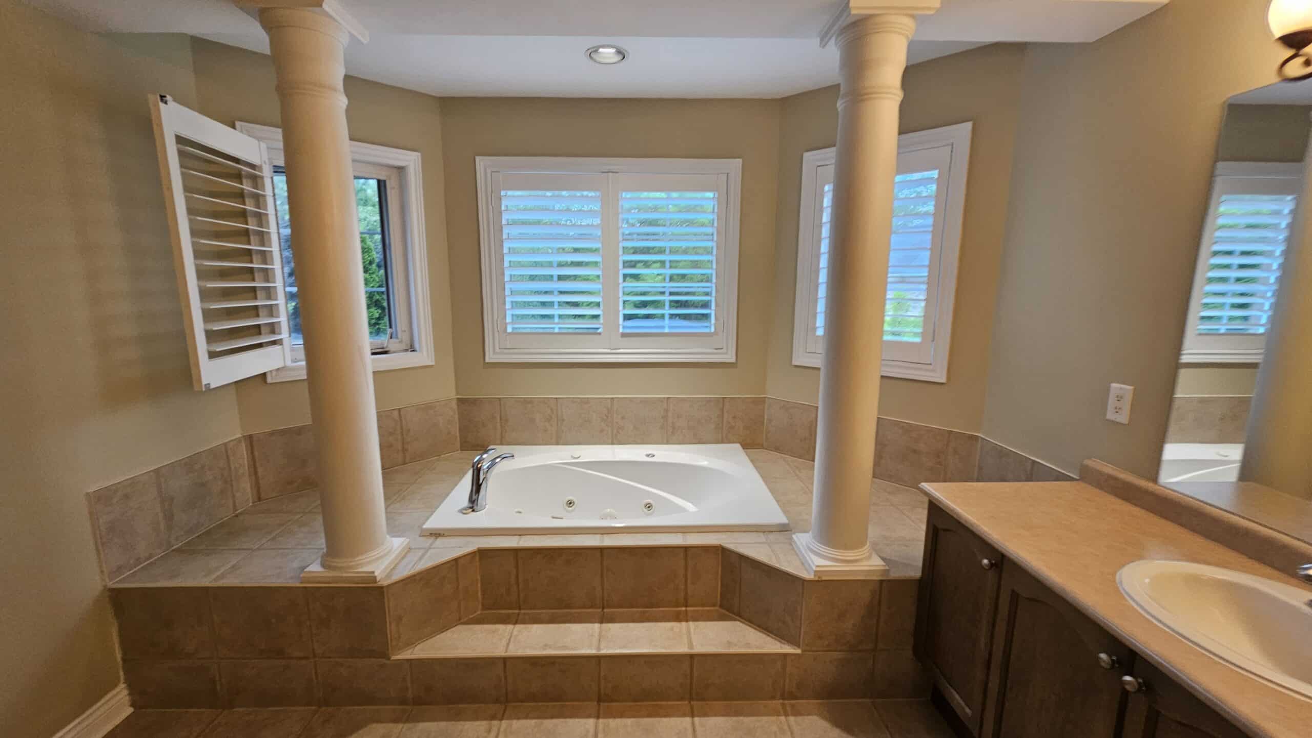 a view of the bathtub area before the renovation with the 2 old columns still in place