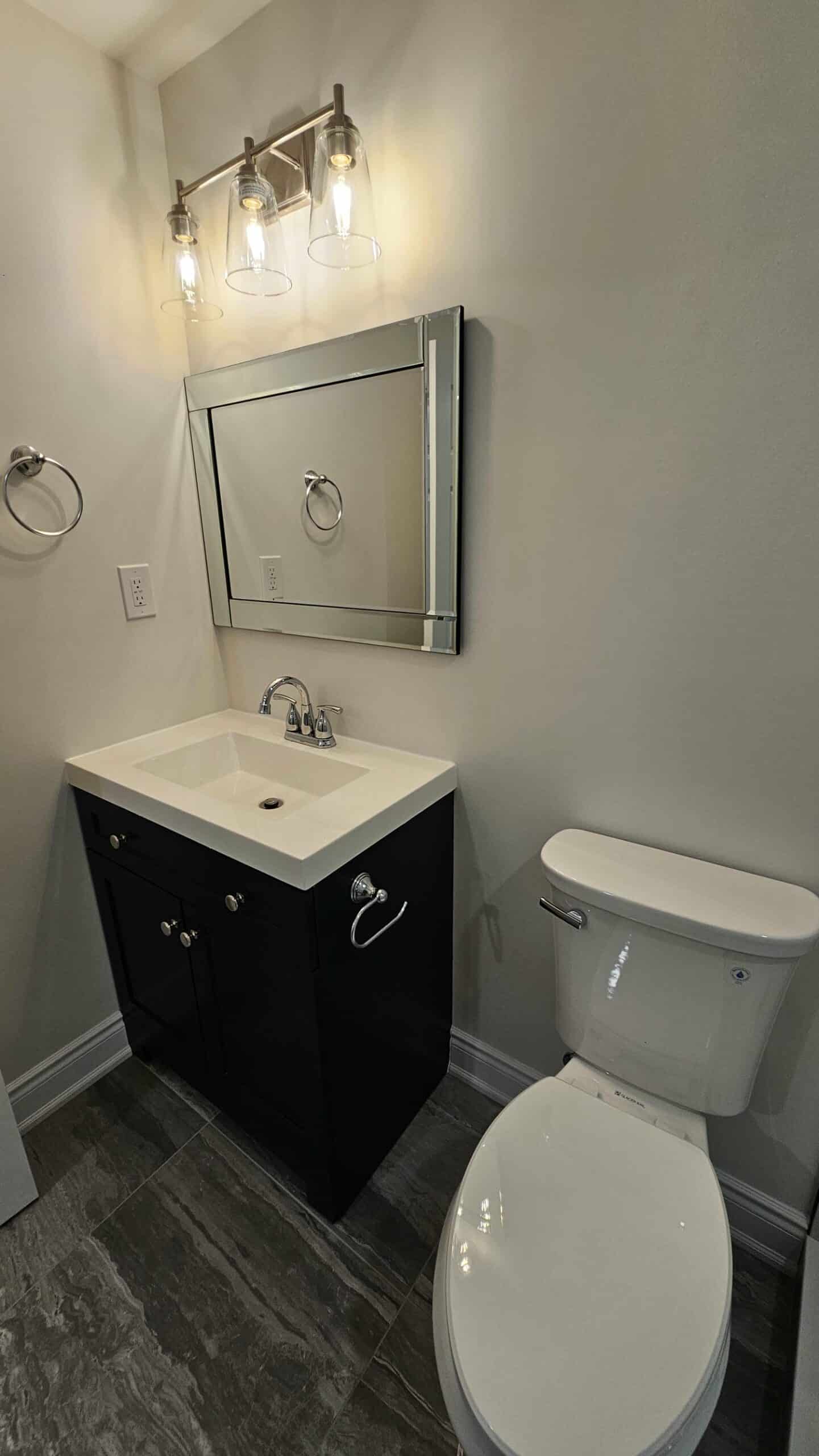 24 inch espresso colored vanity with toilet and chrome accessories