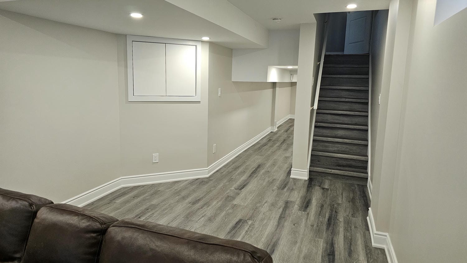 custom electrical panel door with vinyl steps and low section of the basement