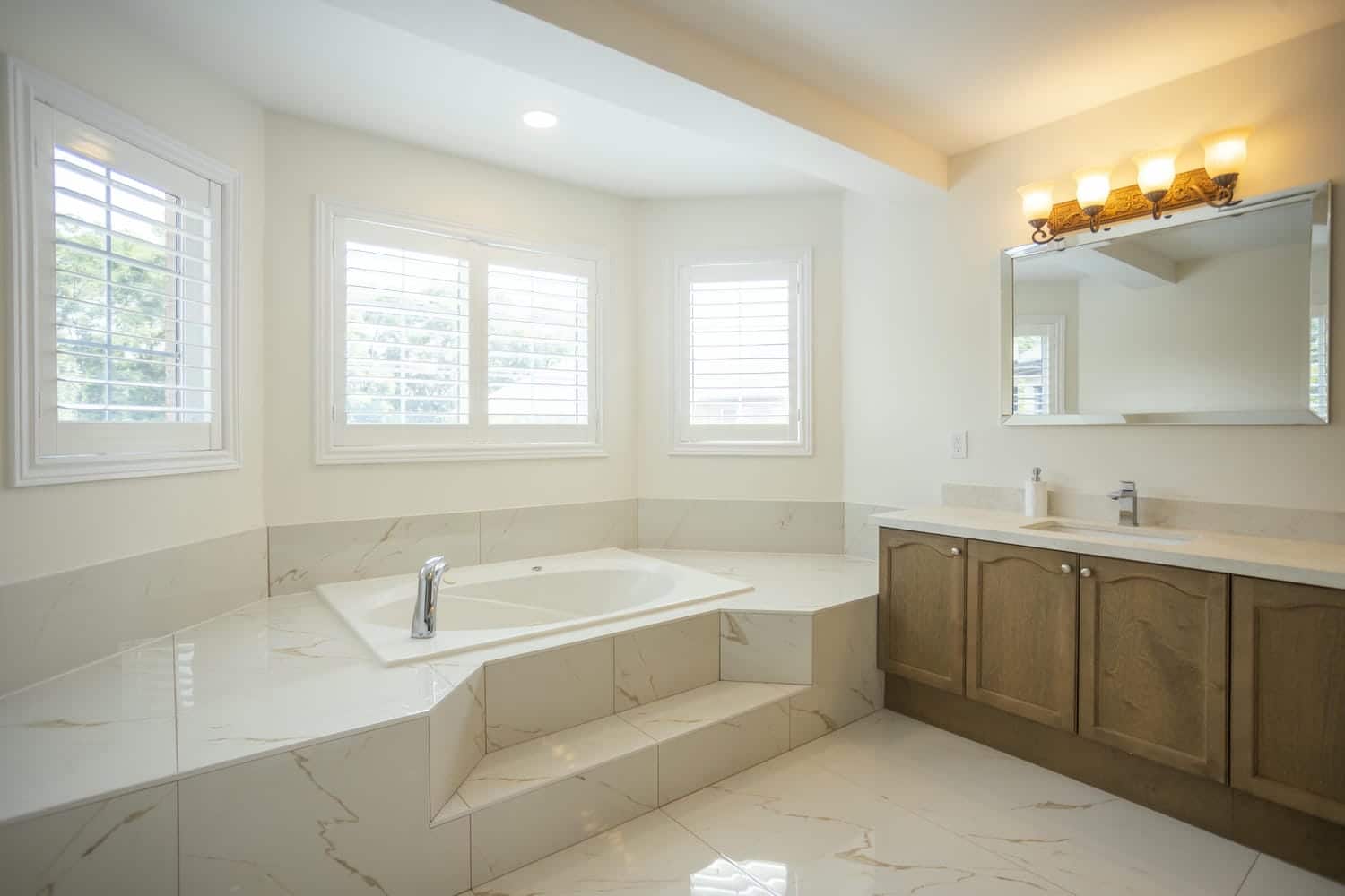 White tiles with golden veins on the floor and surrounding the bath tub with a light colored paint from Benjamin Moore