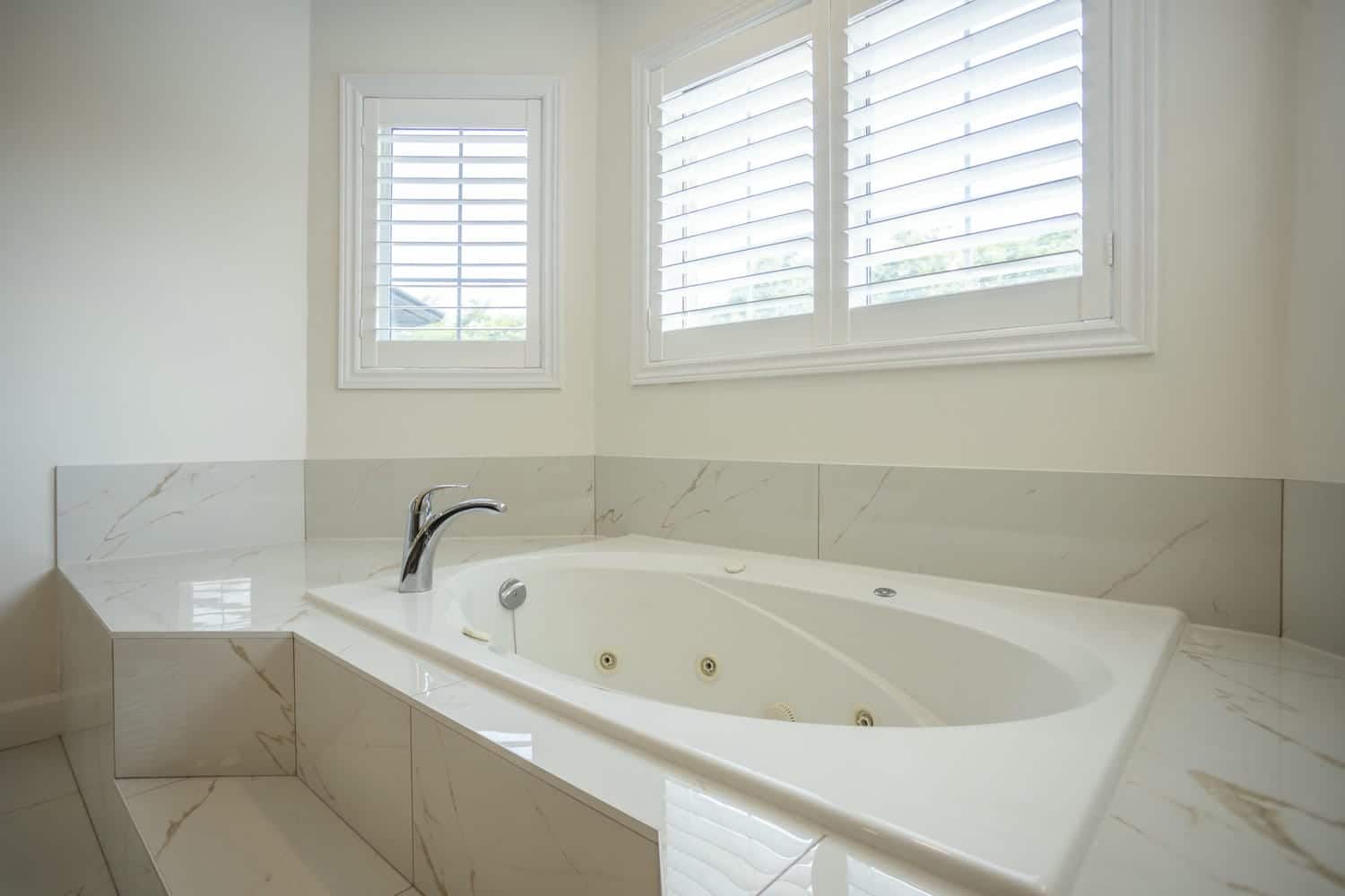 Drop in jet tub with tiled steps leading to the bathtub
