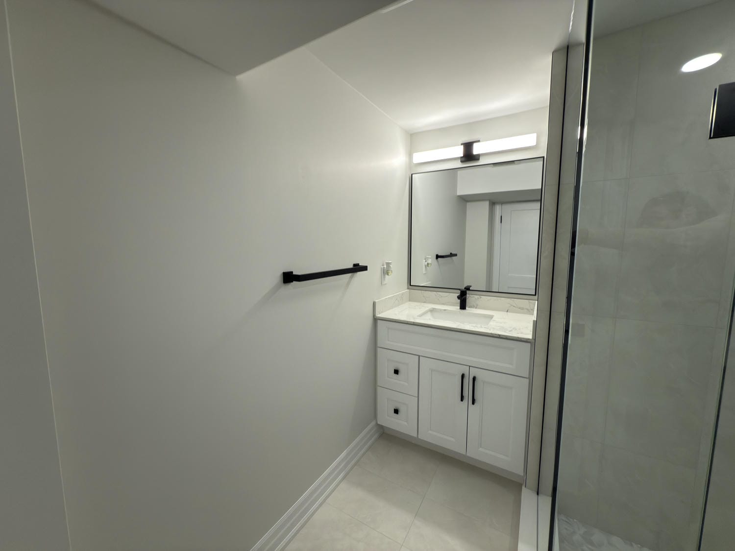 Compact vanity with clean lines and bright lighting. Black accents give it a sharp, modern finish.